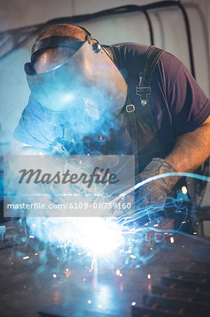 Welder welding a metal in workshop