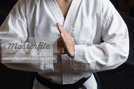 Mid-section of woman practicing karate in fitness studio