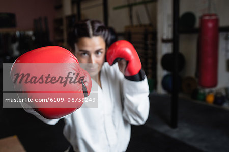 Portrait of woman in boxing gloves at fitness studio
