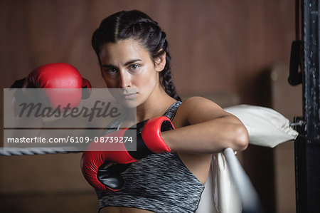 Portrait of tired female boxer in boxing gloves at fitness studio Portrait of tired female boxer in boxing gloves at fitness studio