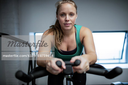 Portrait of pregnant woman working out on exercise bike at gym