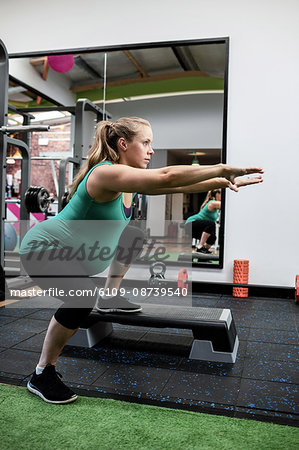 Pregnant woman performing stretching exercise in gym