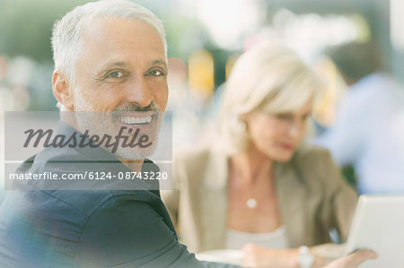 Portrait smiling businessman at sidewalk cafe