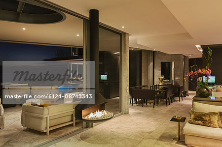 Illuminated luxury modern home showcase interior with hanging fireplace