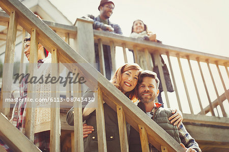 Portrait smiling couple on stairs outside cabin