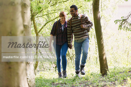 Couple holding hands hiking in woods