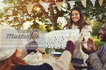 Woman receiving birthday gift at garden party