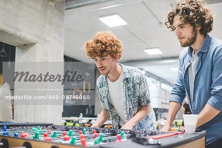 Co-workers playing foosball at break