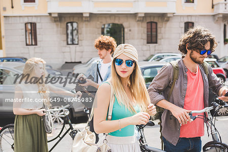 Friends walking along with push bikes