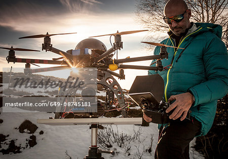 Mature man preparing to fly drone, Stresa, Piedmont, Italy