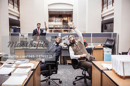 Two businessmen high-fiving in office