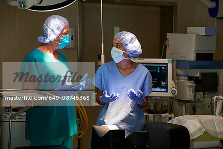 Nurse and surgeon having discussion in hospital theatre
