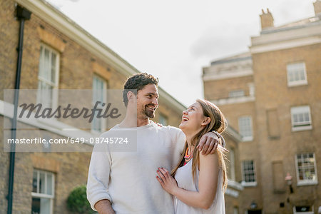 Happy young couple strolling along Kings Road, London, UK