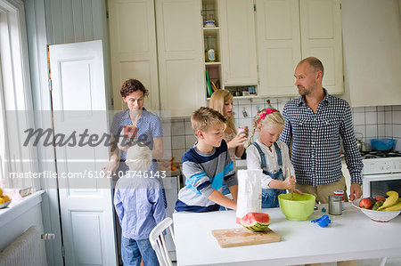 Family preparing food in kitchen