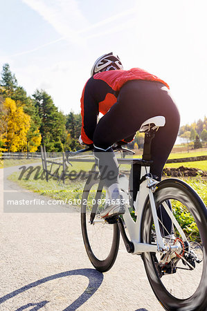 Woman riding bike down country road