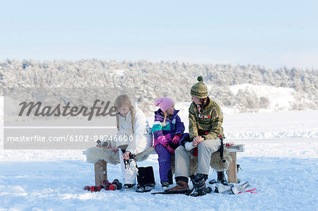 Mother with two daughters sitting on bench