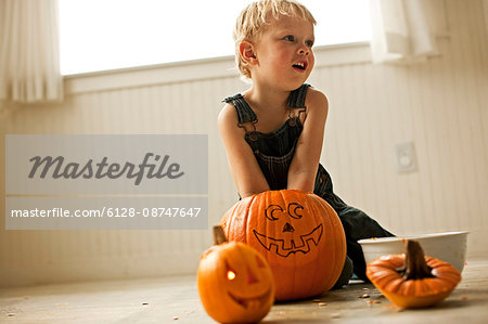 Boy scooping out innards from Halloween pumpkin