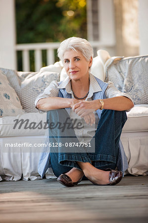 Portrait of a mature woman sitting on her porch.