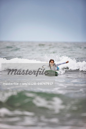 Young woman surfing at the beach.