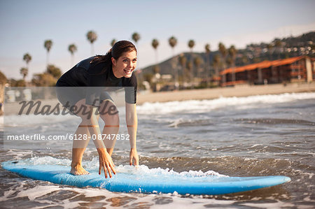 Young woman practising with her surfboard in shallow water.