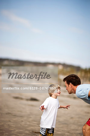Father and son playing at the beach.