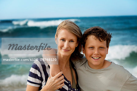 Portrait of a smiling mid-adult woman with her teenage son at the beach.