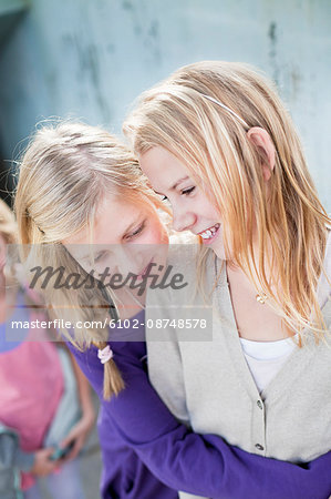 Two smiling girls embracing