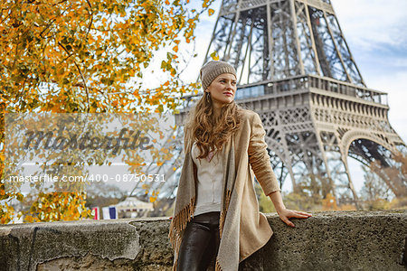 Autumn getaways in Paris. pensive young tourist woman on embankment near Eiffel tower in Paris, France looking into the distance