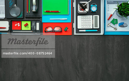 Creative business desktop with colorful office accessories and dark blank copy space, flat lay
