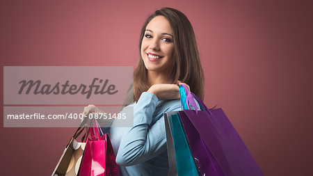 Cheerful smiling woman shopping with lots of colorful bags