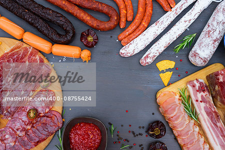 spanish tapas with salami, chorizo, lomo, jamon with red hol salsa sause and olives, picnic table, top view frame with copy space