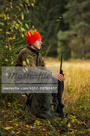 Teenage boy with rifle at hunting