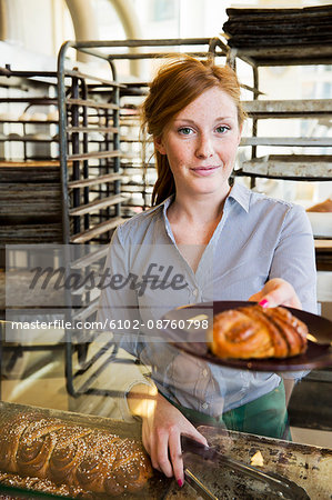Young woman with cinnamon bun on plate, Stockholm, Sweden