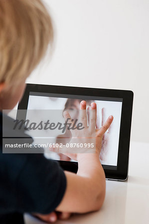 Boy communicating with mother via tablet