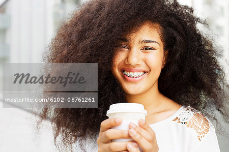 Portrait of smiling teenage girl with disposable cup