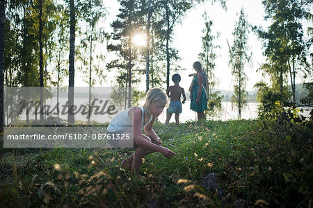 Family walking, girl picking flowers, Dalarna, Sweden