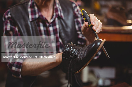 Shoemaker repairing a shoe in workshop