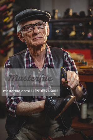 Portrait of shoemaker repairing a shoe in workshop