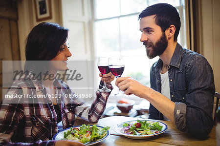 Couple toasting glasses of wine at home