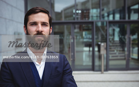 Portrait of businessman standing outside office