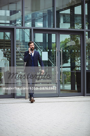 Businessman talking on mobile phone outside office