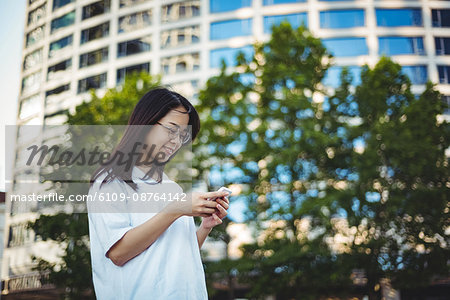 Young woman using mobile phone on street