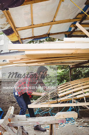 Man preparing wooden boat frame in boatyard