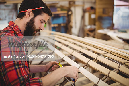 Man preparing a wooden boat frame at boatyard