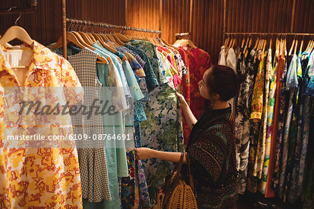 Woman selecting a clothes on hanger at apparel store