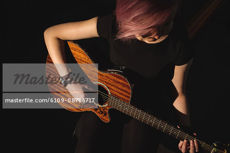 Woman playing a guitar in music school