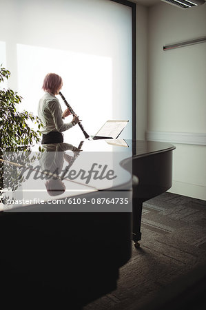 Attentive woman playing a clarinet in music school