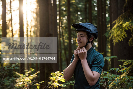 Male athletic wearing bicycle helmet in forest