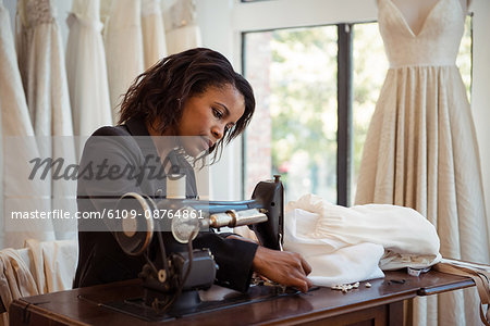 Fashion designer sewing on the sewing machine in the studio