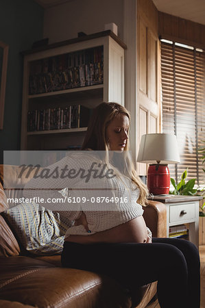 Pregnant woman relaxing in living room at home